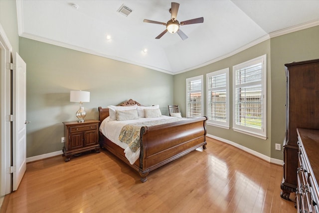 bedroom with vaulted ceiling, light wood-style flooring, crown molding, and baseboards