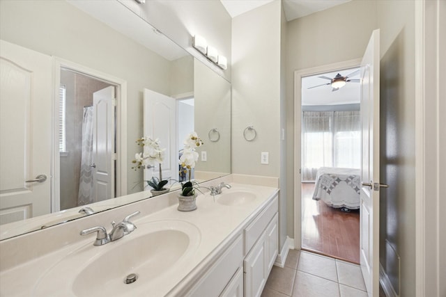 ensuite bathroom with tile patterned flooring, connected bathroom, double vanity, and a sink