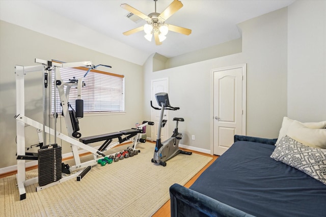 exercise room featuring baseboards, lofted ceiling, and ceiling fan