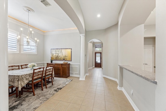 dining room featuring light tile patterned floors, visible vents, arched walkways, and a healthy amount of sunlight