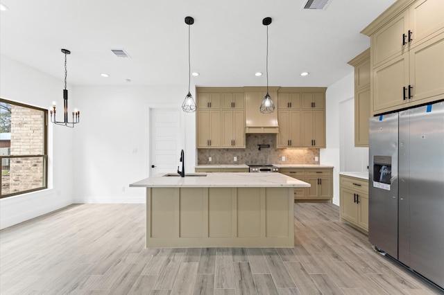 kitchen featuring visible vents, appliances with stainless steel finishes, a sink, light wood-type flooring, and backsplash