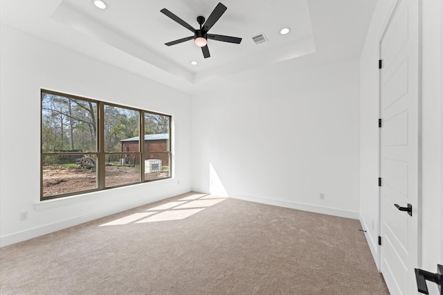 unfurnished bedroom with carpet, a tray ceiling, baseboards, and recessed lighting