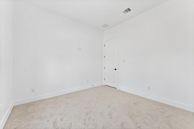 spare room featuring carpet, visible vents, and baseboards