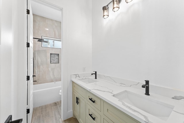 bathroom with double vanity, shower / bath combination, a sink, and wood finish floors