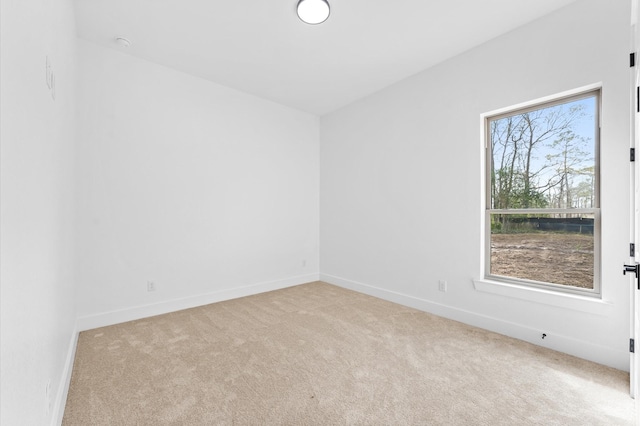 carpeted empty room featuring baseboards