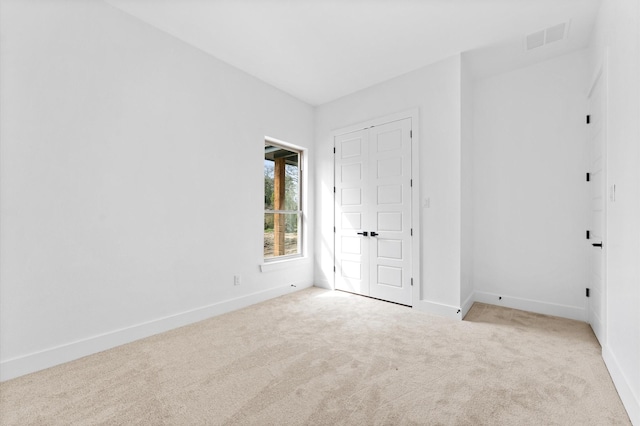 unfurnished bedroom featuring baseboards, visible vents, and carpet flooring