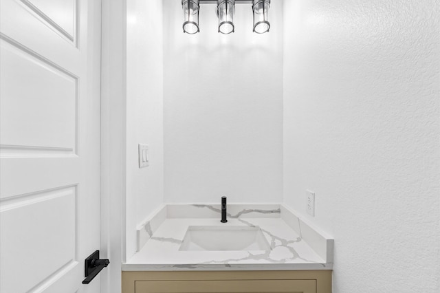 bathroom featuring a textured wall and vanity