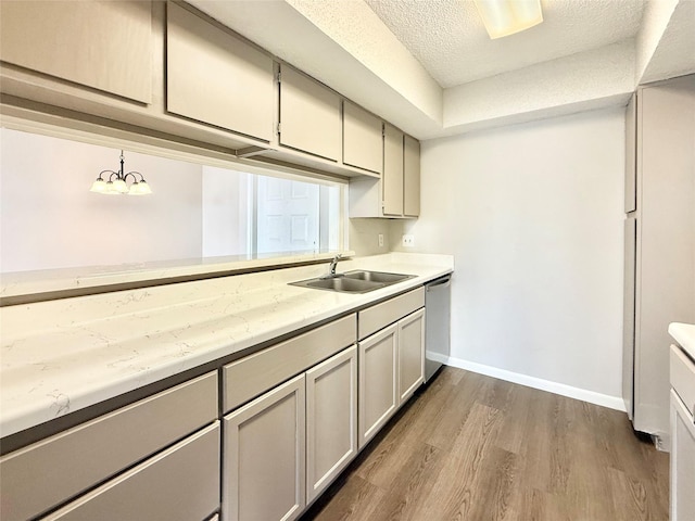 kitchen featuring baseboards, dark wood finished floors, dishwasher, light countertops, and a sink