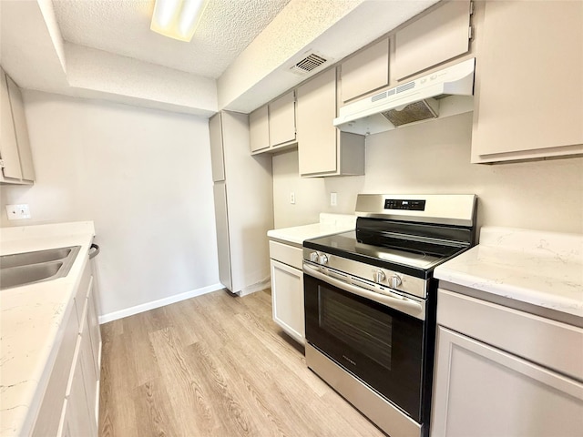 kitchen with visible vents, light wood-style floors, electric stove, under cabinet range hood, and a sink