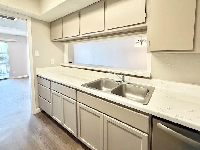 kitchen featuring baseboards, dishwasher, dark wood-type flooring, light countertops, and a sink