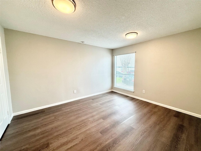 unfurnished room with dark wood-style floors, a textured ceiling, and baseboards