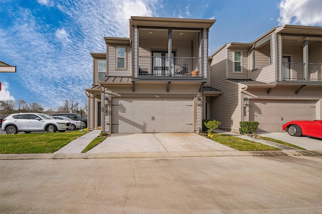 view of property with concrete driveway, an attached garage, a standing seam roof, metal roof, and a balcony