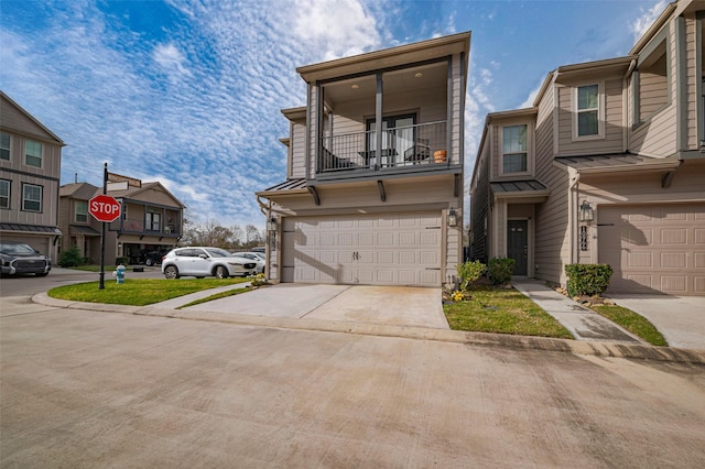 view of property featuring a garage, a standing seam roof, driveway, and a balcony