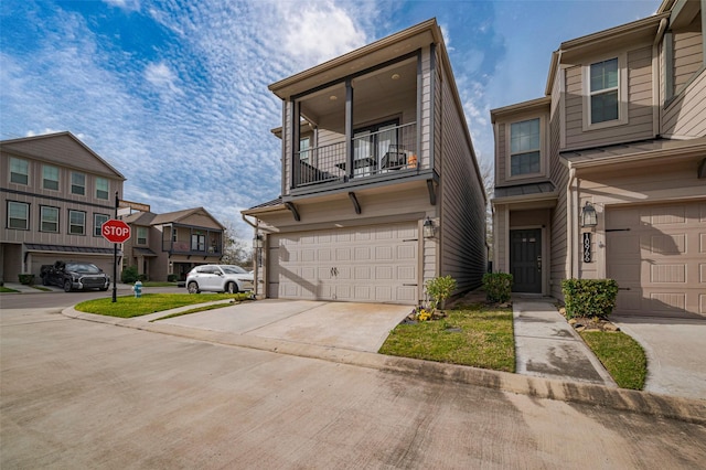 multi unit property featuring concrete driveway, an attached garage, a residential view, and a balcony