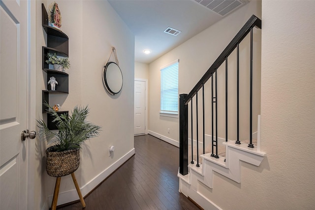 entrance foyer featuring stairs, dark wood finished floors, visible vents, and baseboards