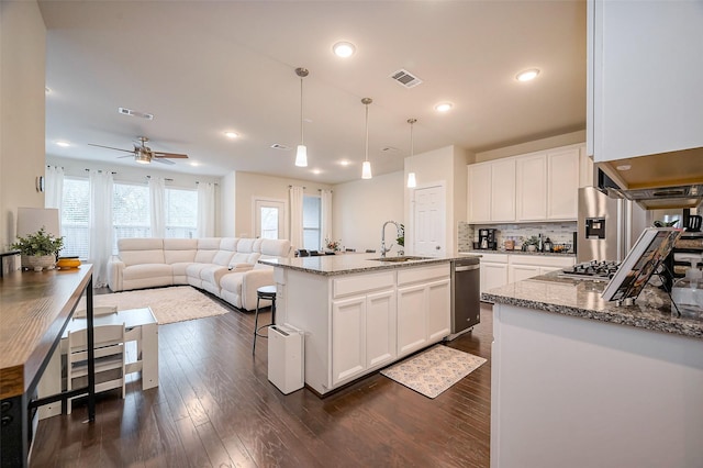 kitchen featuring visible vents, a sink, white cabinetry, and light stone counters