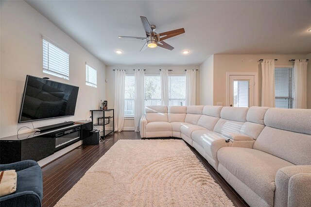 living room with plenty of natural light, a ceiling fan, recessed lighting, and dark wood-type flooring