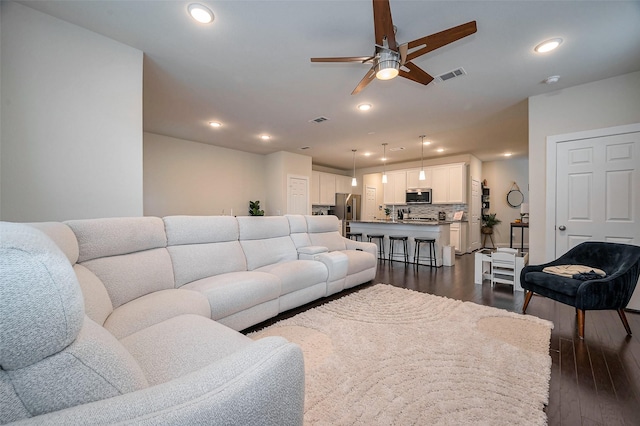 living room featuring ceiling fan, dark wood-type flooring, visible vents, and recessed lighting