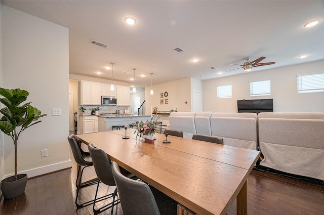 dining space with dark wood-style floors, recessed lighting, visible vents, and baseboards