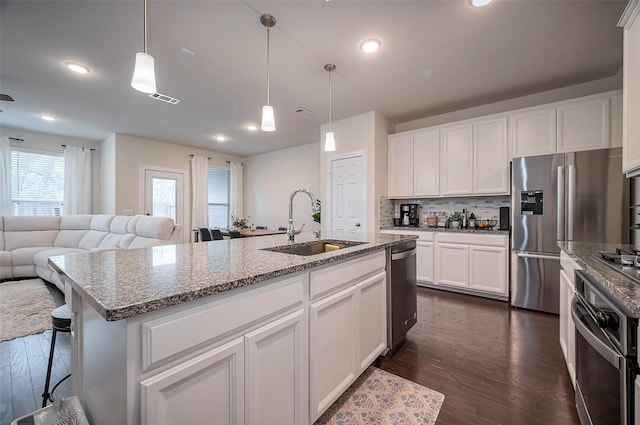 kitchen with a sink, dark wood-style flooring, tasteful backsplash, visible vents, and appliances with stainless steel finishes
