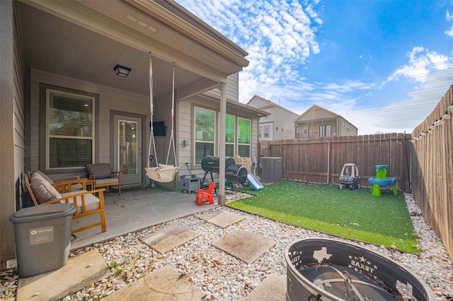 view of patio with a fire pit, central AC, and a fenced backyard