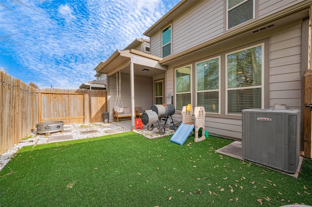 back of property featuring a fenced backyard, a patio, a yard, and cooling unit