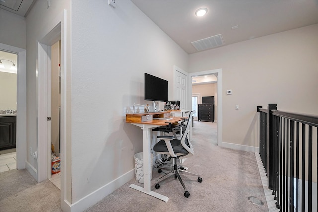 office area featuring visible vents, baseboards, and light carpet