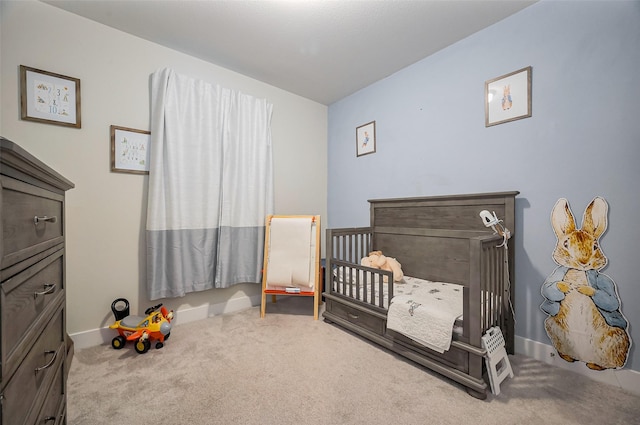 carpeted bedroom with a nursery area and baseboards