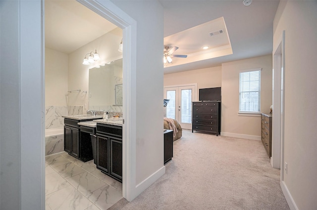 bathroom with visible vents, vanity, a garden tub, a tray ceiling, and french doors