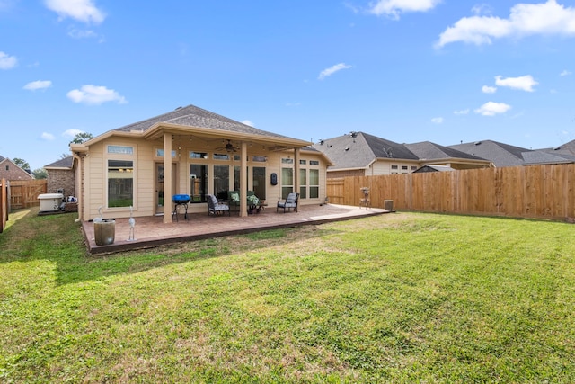 rear view of house with a patio area, a fenced backyard, a ceiling fan, and a yard