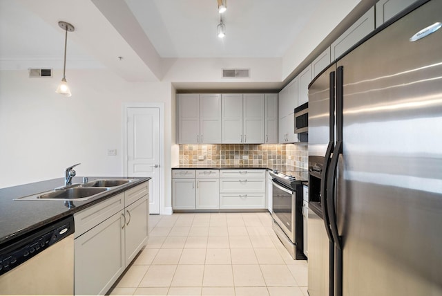 kitchen featuring dark countertops, visible vents, stainless steel appliances, and a sink