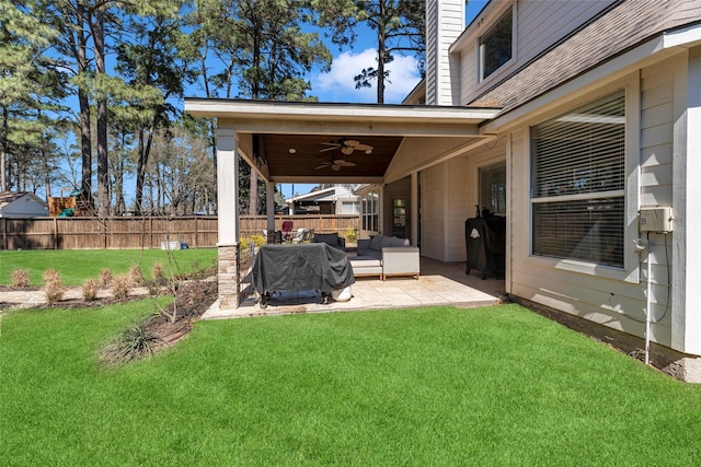 view of yard featuring outdoor lounge area, ceiling fan, fence, and a patio