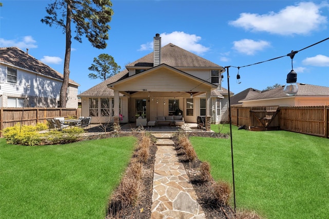 rear view of property featuring a fenced backyard, a lawn, and a patio