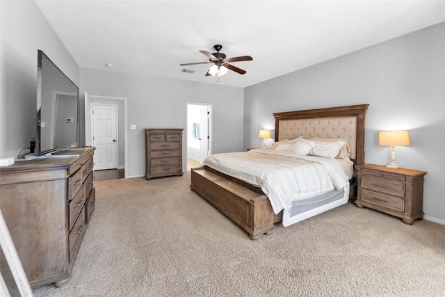 bedroom with light carpet, ceiling fan, visible vents, and baseboards