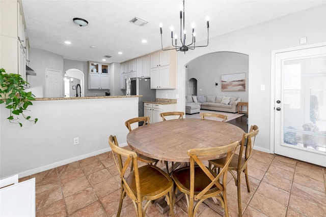 dining space featuring arched walkways, visible vents, an inviting chandelier, and recessed lighting