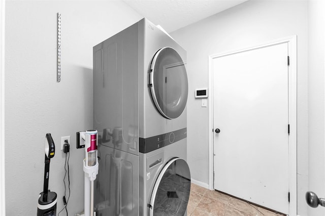 laundry room with a textured ceiling, laundry area, and stacked washer / dryer