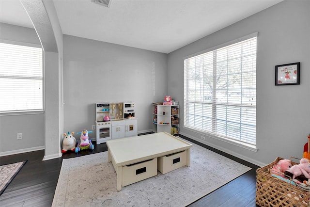 rec room featuring dark wood-style floors, visible vents, and baseboards