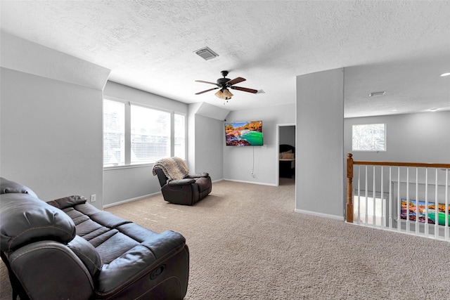 carpeted living area featuring visible vents, ceiling fan, a textured ceiling, and baseboards