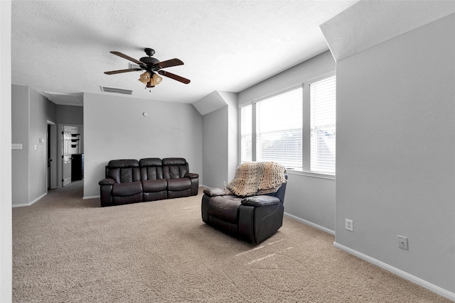 living area with carpet floors, visible vents, ceiling fan, and a textured ceiling