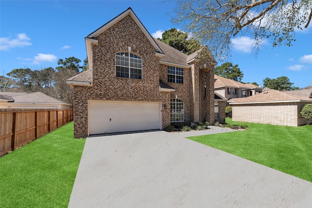 traditional-style home with driveway, brick siding, a front yard, and fence