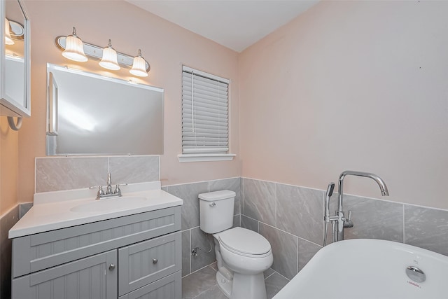 full bathroom featuring a freestanding tub, toilet, a wainscoted wall, vanity, and tile walls