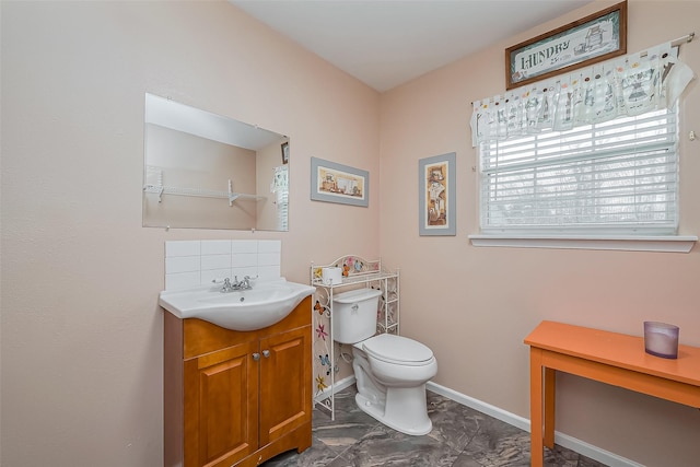 bathroom with toilet, baseboards, decorative backsplash, and vanity