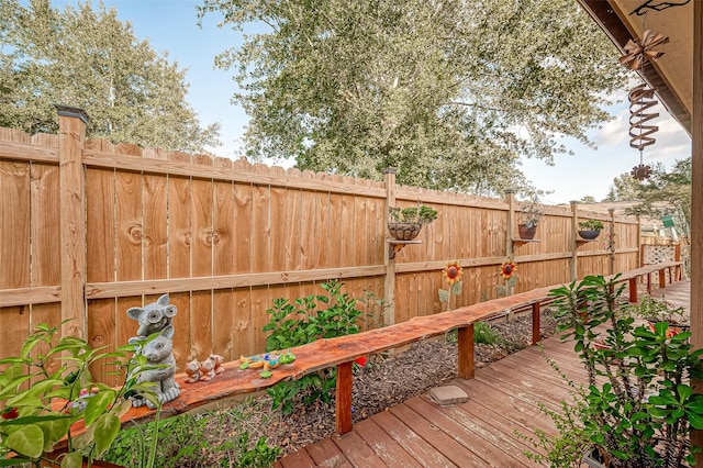 wooden deck with a fenced backyard