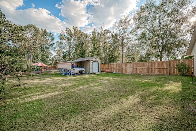 view of yard with a garage, fence, an outdoor structure, and a shed