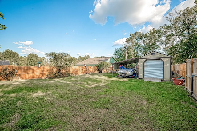 view of yard with a carport, a fenced backyard, an outdoor structure, and a storage unit