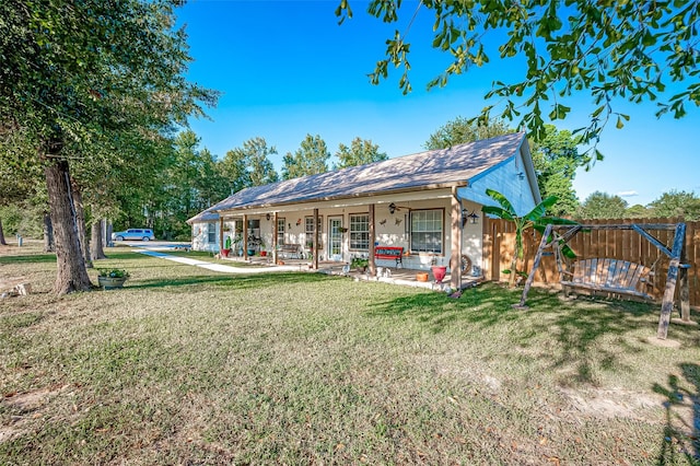 view of front facade featuring ceiling fan, a front lawn, a patio area, and fence