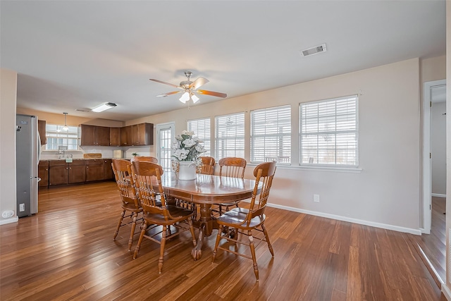 dining room with a healthy amount of sunlight, wood finished floors, visible vents, and baseboards