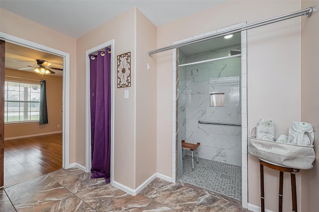 full bath featuring tiled shower, a ceiling fan, and baseboards