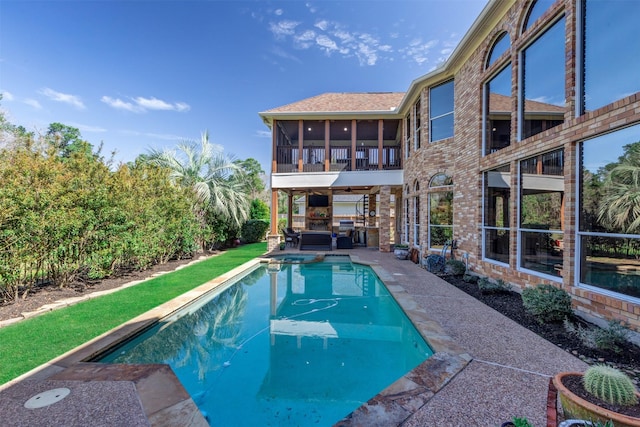 view of pool with a patio, a pool with connected hot tub, and a sunroom