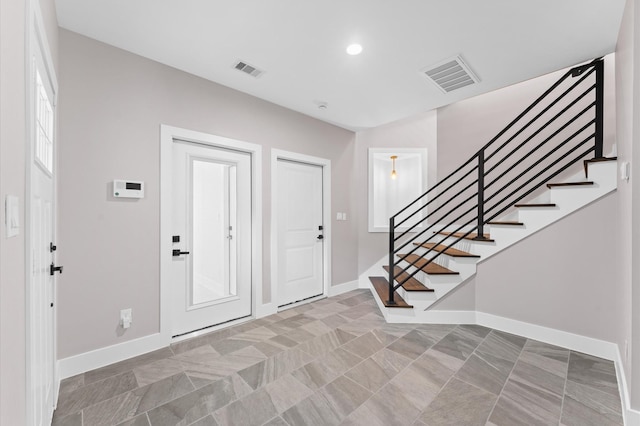 entryway with visible vents, recessed lighting, stairway, and baseboards